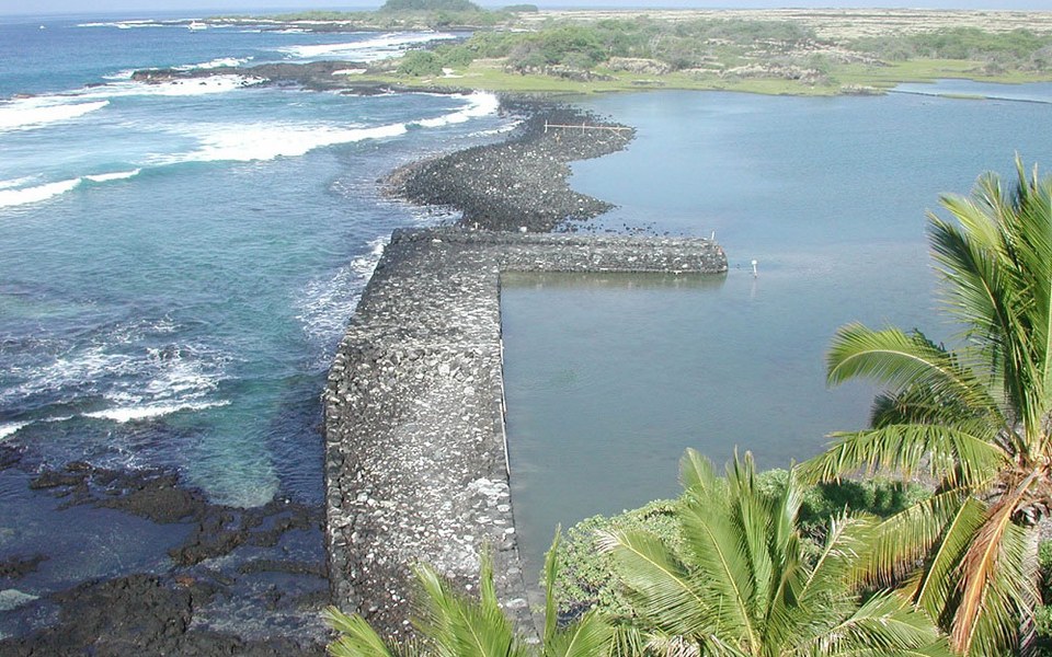 Historic volcanic-rock fishpond wall and turquoise Pacific surf at Kaloko-Honokōhau near Kailua-Kona, Hawaii